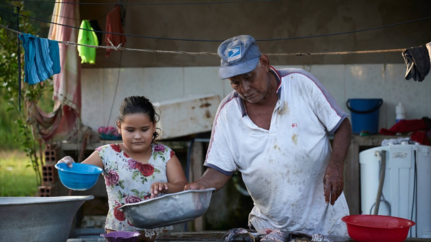 Per cena viene messo in tavola del pesce. Luis Pinto, il padre di Javier Pinto, prepara il pasto con la nipotina.