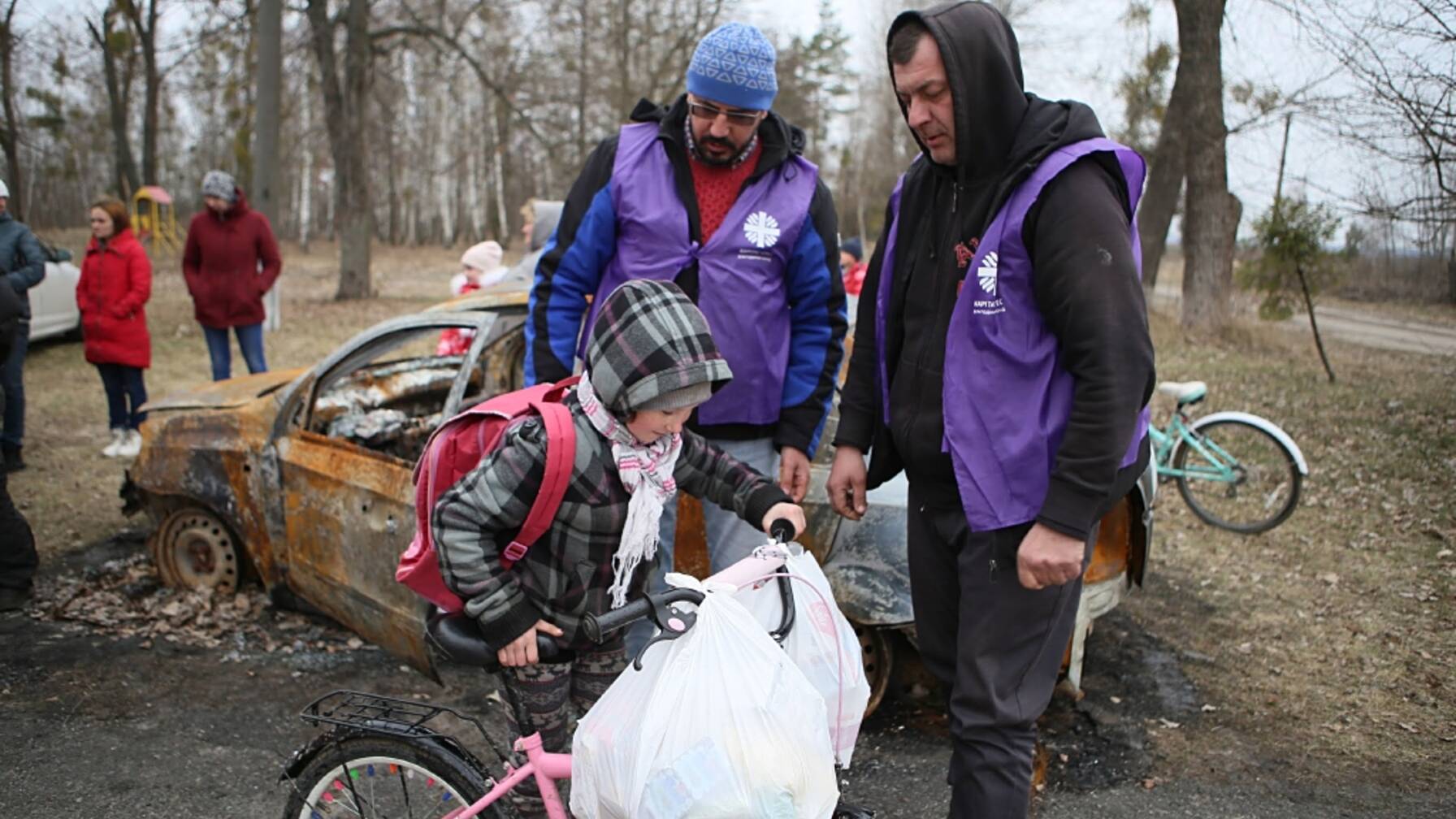 Soccorritori in caso di catastrofe: nella città ucraina di Bucha un bambino riceve generi alimentari da Caritas. 