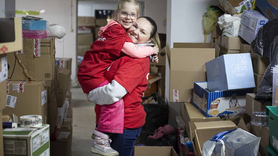 Avec sa fille Victoria de 6 ans, Katharina s’engage bénévolement au centre logistique de Caritas à Lublin, en Pologne.