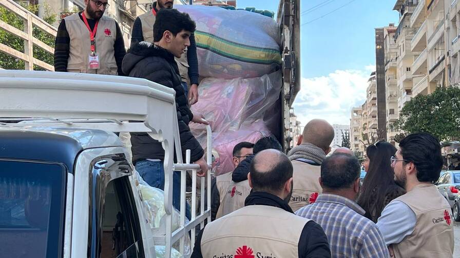Mitarbeitende von Caritas Syrien transportieren Hilfsgüter.