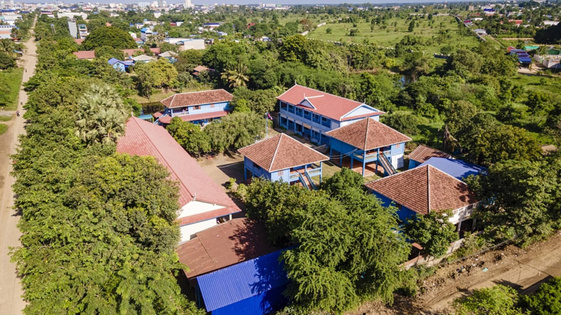An inviting school campus surrounded by many trees. 