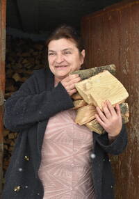 L'Ukrainienne Iryna avec du bois de chauffage provenant du projet de Caritas «Warm for Winter».