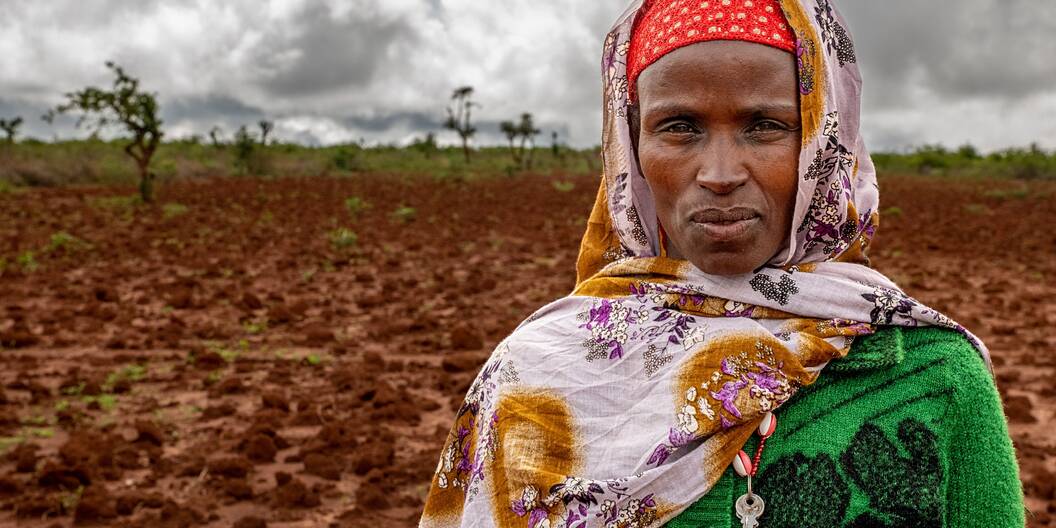 Die Kleinbäuerin Ensane aus Äthiopien schaut direkt in die Kamera. Das Feld hinter ihr ist von der starken Dürre ausgetrocknet.
